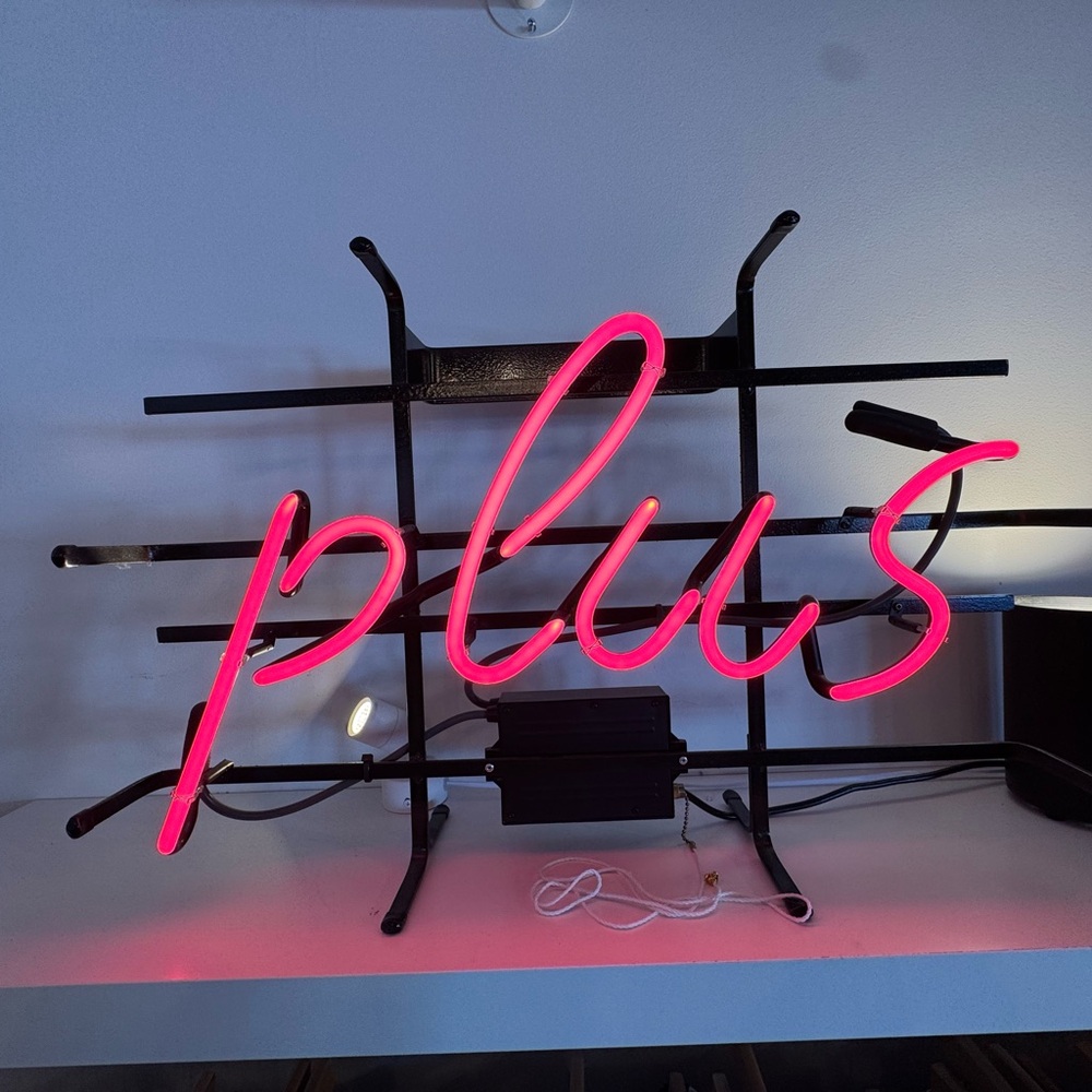 ‘Plus’ neon pink wall sign